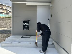 玄関の掃き掃除をしている様子
